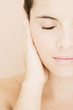Portrait of young woman holding her hand beside her face, eye closed