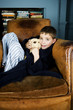 Little boy sitting in armchair with teddy bear