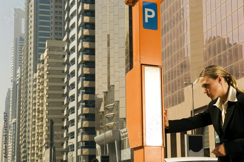 Photo: A businesswoman using a parking meter A businesswoman using a parking meter