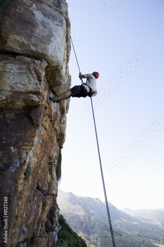 Photo: A climber climbing a rock face A climber climbing a rock face