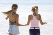 Photo: Two young girls running on the beach hand in hand Two young girls running on the beach hand in hand