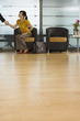 Photo: Businesswoman sitting in office reception area, shaking hands with businessman, surface level Businesswoman sitting in office reception area, shaking hands with businessman, surface level