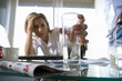 Photo: Young businesswoman at desk holding glass with soluble tablet, head in hand, focus on glass (differential focus) Young businesswoman at desk holding glass with soluble tablet, head in hand, focus on glass (differential focus)