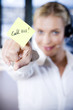 Businesswoman in a call centre with a sticky note saying Call Me