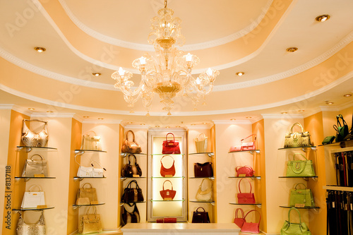 Photo: Selection of designer handbags on shelf display in glamorous boutique Selection of designer handbags on shelf display in glamorous boutique