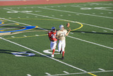 Photo: American football player chasing opposing receiver about to catch ball during competitive game American football player chasing opposing receiver about to catch ball during competitive game