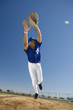 Photo: Baseball player, in blue uniform, diving to catch ball in protective glove during competitive game (surface level, tilt) Baseball player, in blue uniform, diving to catch ball in protective glove during competitive game (surface level, tilt)