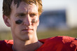 Photo: American football player wearing red football strip and black face paint, close-up, front view American football player wearing red football strip and black face paint, close-up, front view