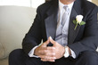 Photo: Senior groom, in formalwear, sitting on chair at wedding, thumbs pressed together, mid-section Senior groom, in formalwear, sitting on chair at wedding, thumbs pressed together, mid-section