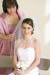 Photo: Bride sitting on bench at wedding, senior woman adjusting bride’s veil, smiling, portrait Bride sitting on bench at wedding, senior woman adjusting bride’s veil, smiling, portrait