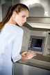 Portrait of a young woman using an ATM cash machine