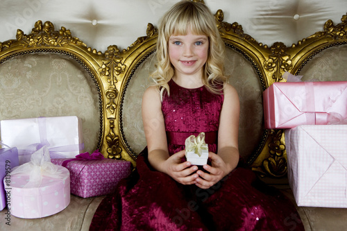 Foto: Little girl holding out a birthday present Little girl holding out a birthday present