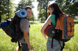 Photo: Young couple standing in woodland clearing on camping trip, carrying rucksacks and sleeping bags, looking over shoulder, smiling, rear view, portrait Young couple standing in woodland clearing on camping trip, carrying rucksacks and sleeping bags, looking over shoulder, smiling, rear view, portrait