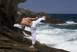 A man practicing Tai Chi by the sea