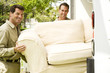 Removal men with sofa beside their van