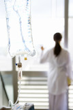 Photo: IV bag, young female patient looking out window in background (differential focus) IV bag, young female patient looking out window in background (differential focus)