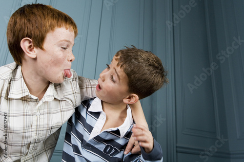 Photo: older boy poking tongue out at younger boy older boy poking tongue out at younger boy