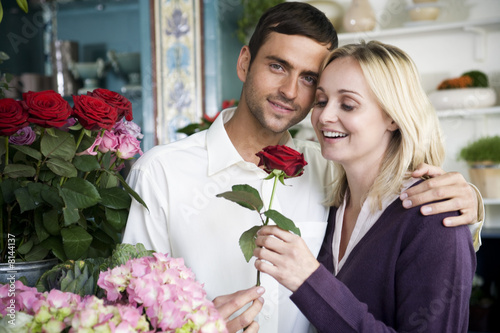 Foto: Couple choosing flowers in a florist's shop, red roses Couple choosing flowers in a florist's shop, red roses