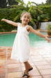 little Hispanic girl dancing on terrace by pool