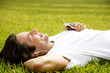 Man lying on the grass listening to personal stereo