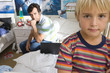 Father on bed looking at son (6-8), close-up of boy (differential focus)
