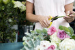 Woman's hands tying together a bouquet of pink and white roses