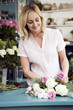 Woman florist creating a bouquet of pink and white roses