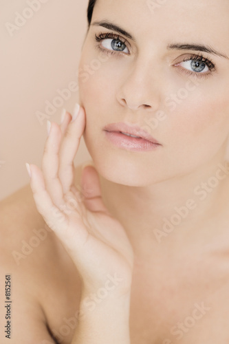 Photo: Portrait of young woman touching her cheek Portrait of young woman touching her cheek