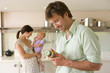 Photo: Young couple in kitchen, pregnant woman with baby girl (6-9 months), man looking at baby food label Young couple in kitchen, pregnant woman with baby girl (6-9 months), man looking at baby food label
