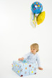 Baby boy (6-9 months) with baloons and present