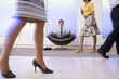 Photo: Businessman meditating in chair in office foyer, colleagues walking past, low section (blurred motion) Businessman meditating in chair in office foyer, colleagues walking past, low section (blurred motion)