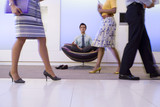 Photo: Businessman meditating in chair in office foyer, colleagues walking past, low section (blurred motion) Businessman meditating in chair in office foyer, colleagues walking past, low section (blurred motion)