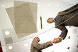 Photo: Two businessmen shaking hands by paperwork and pen on glass table, low angle view through glass Two businessmen shaking hands by paperwork and pen on glass table, low angle view through glass