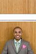 Photo: Businessman under light on wall with heart shaped decoration on jacket, smiling, portrait Businessman under light on wall with heart shaped decoration on jacket, smiling, portrait