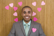 Photo: Businessman by wall covered in heart shaped decorations, one on jacket, smiling, portrait, close-up Businessman by wall covered in heart shaped decorations, one on jacket, smiling, portrait, close-up