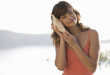 A woman holding a shell to her ear