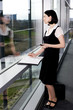 Photo: Businesswoman or secretary with an appointments diary, staring out of the window Businesswoman or secretary with an appointments diary, staring out of the window
