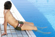 Young man relaxing by a swimming pool