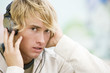 Portrait of a young man listening to music in front of a graffiti covered wall