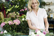 Woman florist creating a bouquet of pink and white roses