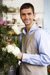 Male florist amongst the flowers in his shop