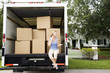 Woman moving home, sitting in the removal van and talking on her mobile phone