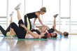 Photo: Female fitness instructor teaching class in studio in gym, hand on man's leg, portrait of man smiling Female fitness instructor teaching class in studio in gym, hand on man's leg, portrait of man smiling