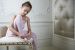 Young girl putting on her ballet shoes