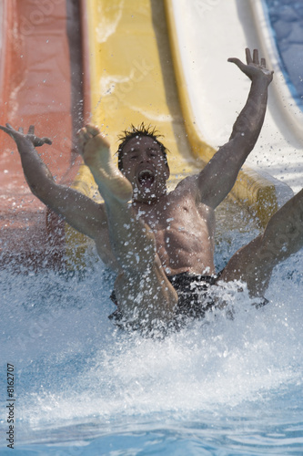 Photo: A man coming down a slide in a waterpark A man coming down a slide in a waterpark