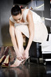 Woman trying on high-heeled sandals and shoes in a shoe shop