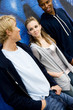 Portrait of a group of young friends hanging out in front of a graffiti covered wall