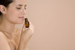 Woman smelling a bottle of essential oil