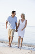 Couple at the beach holding hands and smiling