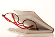 red reading glasses between a book